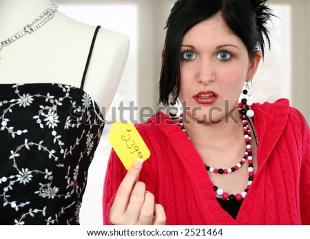 Beautiful young woman disgusted with price tag on dress.