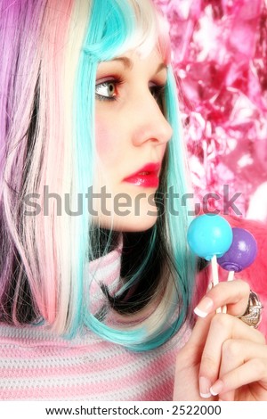 Beautiful young woman in rainbow colored hair with lollipops.