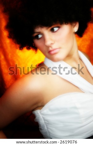 Beautiful young woman with curly black hair in white formal dress.