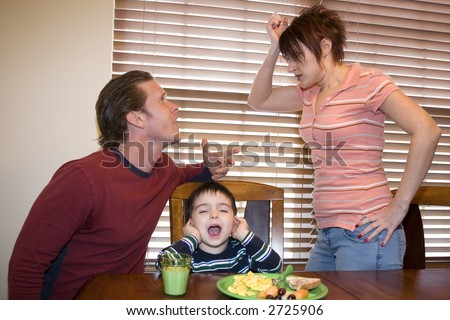 Thirty something couple at home fighting with upset son between them.