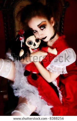 Fantasy goth portrait of woman in goth doll dress with matching doll.