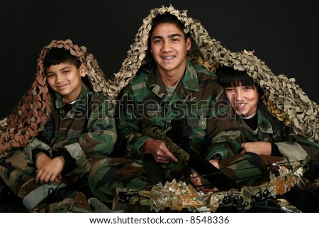 Three Filipino brothers in camo fatigues with crossbow and hunting gear.