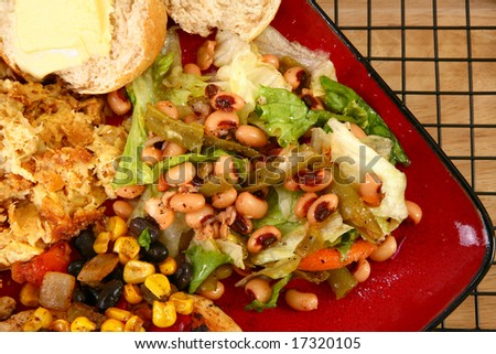 Black eye pea salad in plate with baked squash and roll.