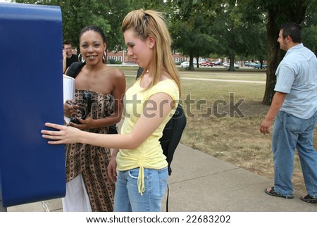 College students on campus at payphone.