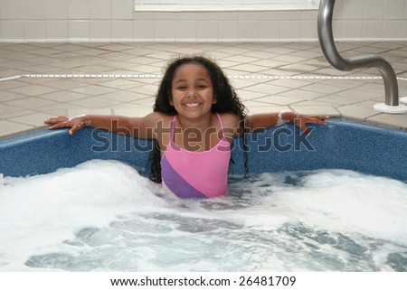 Adorable African American 8 year old girl in hot tub.