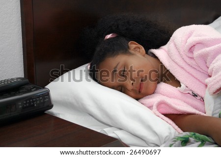 Adorable five year old African American Girl Sleeping in bed.