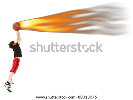 Energetic 8 year old boy child in basketball uniform jumping to catch ball on fire.
