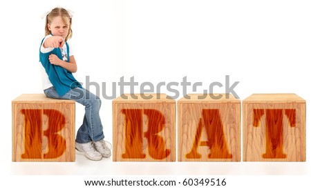 Angry american 7 year old girl sitting on blocks spelling the word brat over white background. Stock fotó © 
