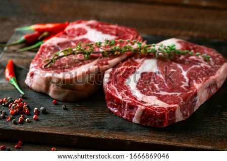Two classic fresh rib eye steaks on a wooden Board