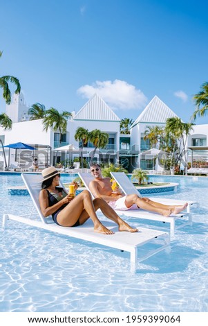 Luxury resort with swimming pool near Palm Beach Aruba Caribbean, couple man and woman mid age on a luxury vacation in the Caribbean