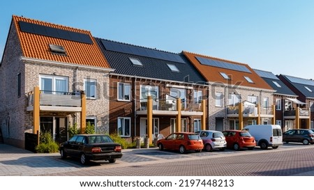 Newly build houses with solar panels attached on the roof against a sunny sky Close up of a new building with black solar panels. Zonnepanelen, Zonne energie, Translation: Solar panel, , Sun Energy.  Stock foto © 