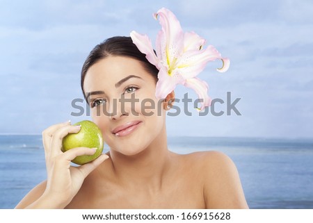 Beautiful,sensual woman on seaside with apple in hand