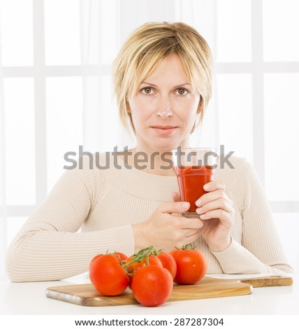 Forty years woman \
drinking tomatoes juice
