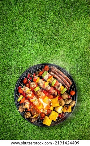 Top view of bbq grill, grilled meat, vegetables, mushrooms with flames and smoke. Placed on green grass lawn. Grilled food, vertical composition. Photo stock © 