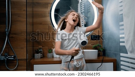 Image, Stock Photo Little girl singing holding headphones cord imitating herself a real singer. Child having fun jumping dancing listening to music on bed in bedroom at home