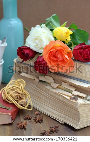 vintage composition with a old books, roses, cups and cinnamon