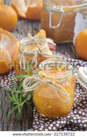 homemade mandarin marmalade with rosemary in a small glass jar