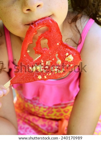 little girl with a red heart candy. selective focus