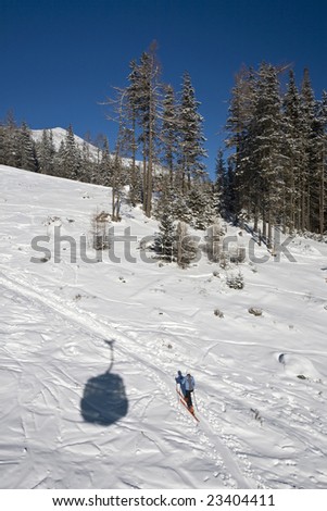 Lonely skier running cross-country hill