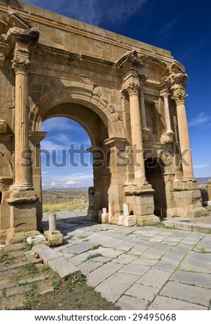 Algeria. Timgad (ancient Thamugadi or Thamugas). Triumphal arch, called Trajan\'s Arch (Corinthian order with three arches) and paving stones of Decumanus Maximus street