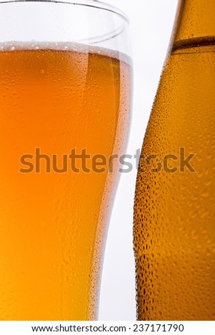 Beer bottle features a glass of beer and water isolation on white