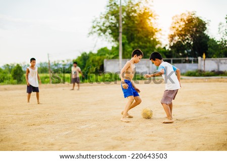 kids are playing football under the sun light