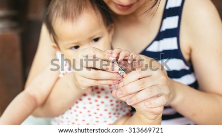 Mother try to nail cutting for her ten months baby.