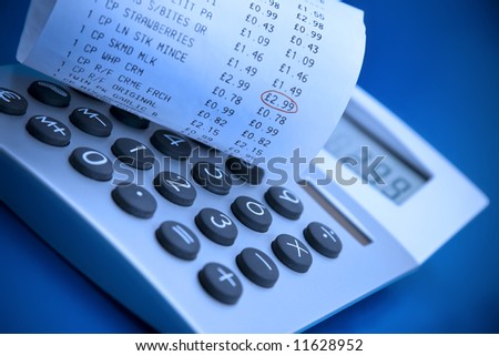 Checking supermarket cash register receipt with calculator
