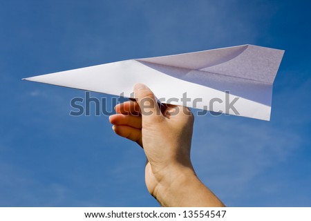 Hand throwing a paper plane