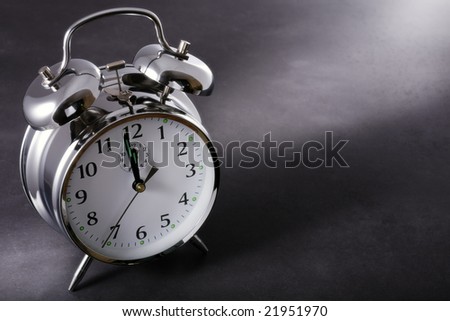 Alarm clock at night just before midnight on a dark background