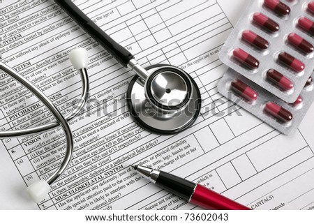 Stethoscope, pen and pill capsules resting on medical examination notes or patient record form