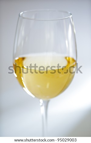 Glass of white wine against white background with soft focus