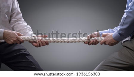 Two businessmen pulling tug of war with a rope concept for business competition, rivalry, challenge or dispute 商業照片 © 