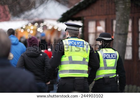 Police in hi-visibility jackets policing crowd control at a UK event