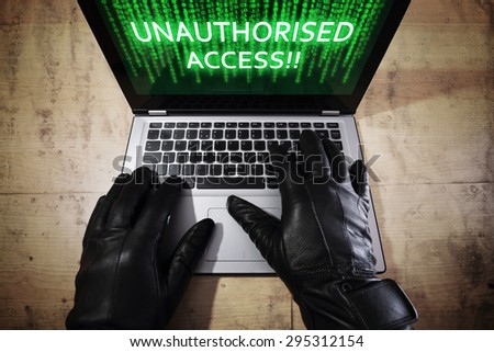 Computer hacker stealing data from a laptop concept for network security, identity theft, computer crime and unauthorised access