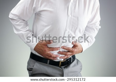 Businessman holding his stomach in pain with  stomachache or indigestion