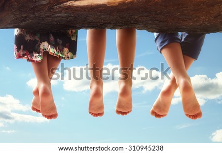 Foto Bild Person sitzt mit baumelnden Beinen auf Stein über dem Bergtal