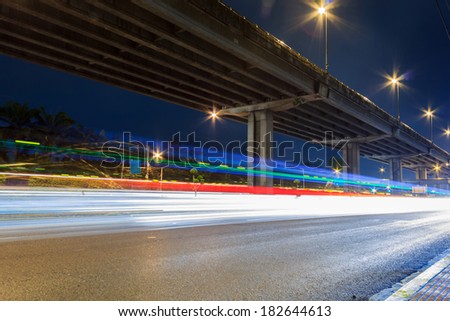 Long exposure image of cars rushing under expressway