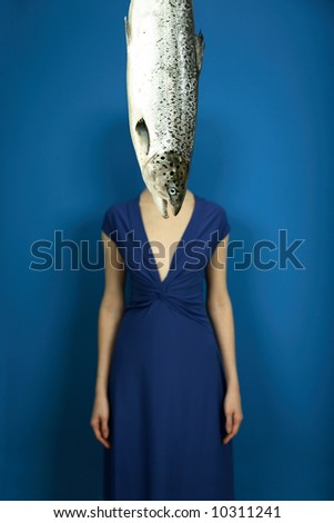 fashionable elegant girl with big fish on blue background
