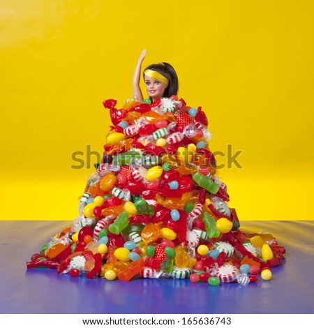 A generic doll is overwhelmed by a pile of generic candy.