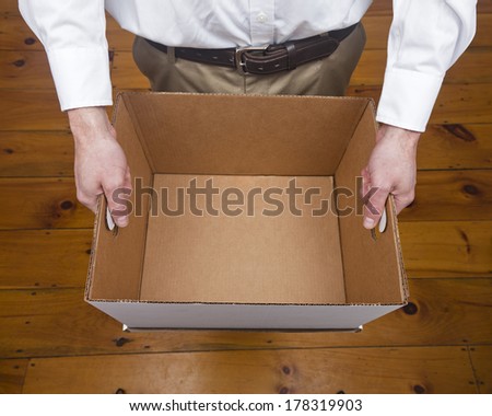 A caucasian male holding an empty cardboard box.