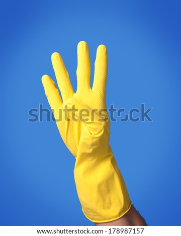 A male caucasian hand wearing yellow latex glove with four fingers extended.