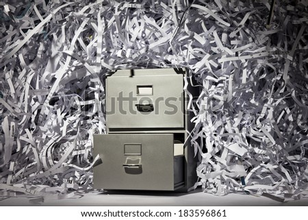 A file cabinet surrounded by lots of shredded paper.