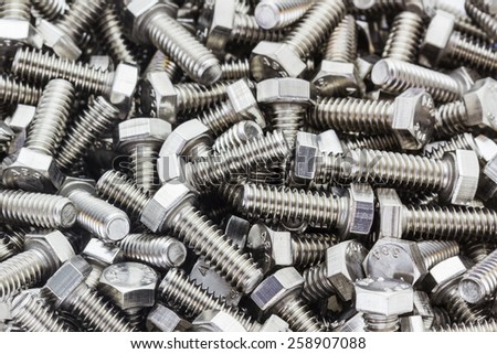 Closeup metal screw (bolt) and nuts on texture background.