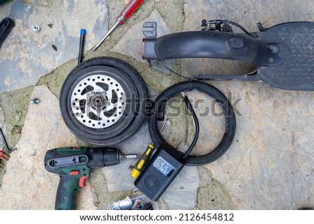 Electric scooter bicycle (Bike) wheel, tire repair. Inflating the tire with an electric air pump to find the puncture before patching with the repair kit.
 Stock fotó © 