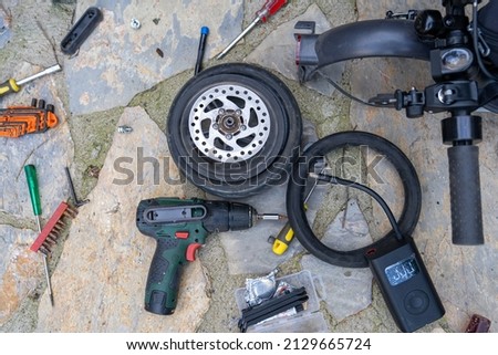 Electric scooter bicycle (Bike) wheel, tire repair. Inflating the tire with an electric air pump to find the puncture before patching with the repair kit.
 Stock fotó © 