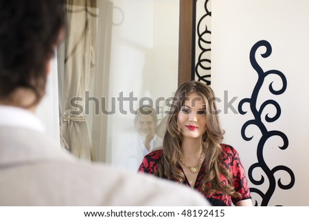 young couples looking each other with love. Reflection of man beside the woman .