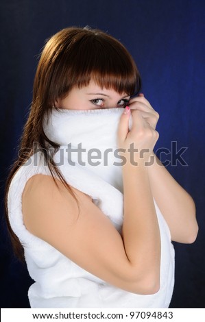 The girl hides face for artificial fur. Looking at camera