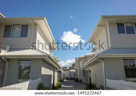 New residential townhouses in Melbourne’s suburb. VIC Australia. Common walkway between homes. Townhouses in Australia are connected to one another in a row, and are usually two or three stories tall.