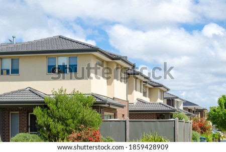 A row of Australian modern suburban townhouses in Melbourne's residential neighbourhood. Townhouses in Australia are connected to one another in a row and are usually two or three stories tall.